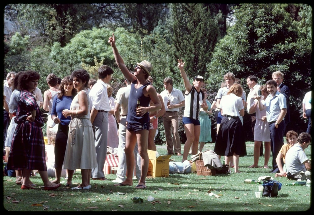 A group of office staff enjoy a Christmas party in Treasury Gardens, Melbourne. 