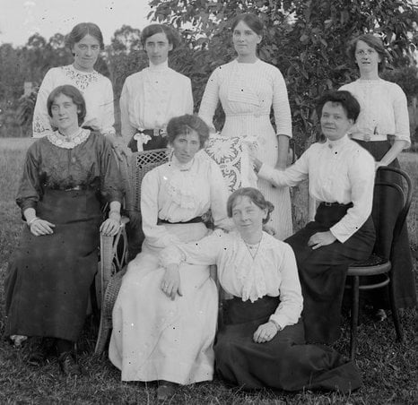Eight women gathered on a lawn