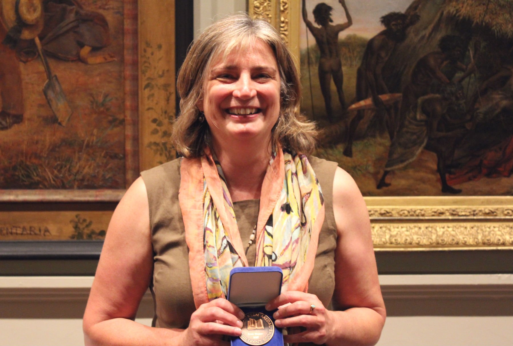 A woman holding a medal