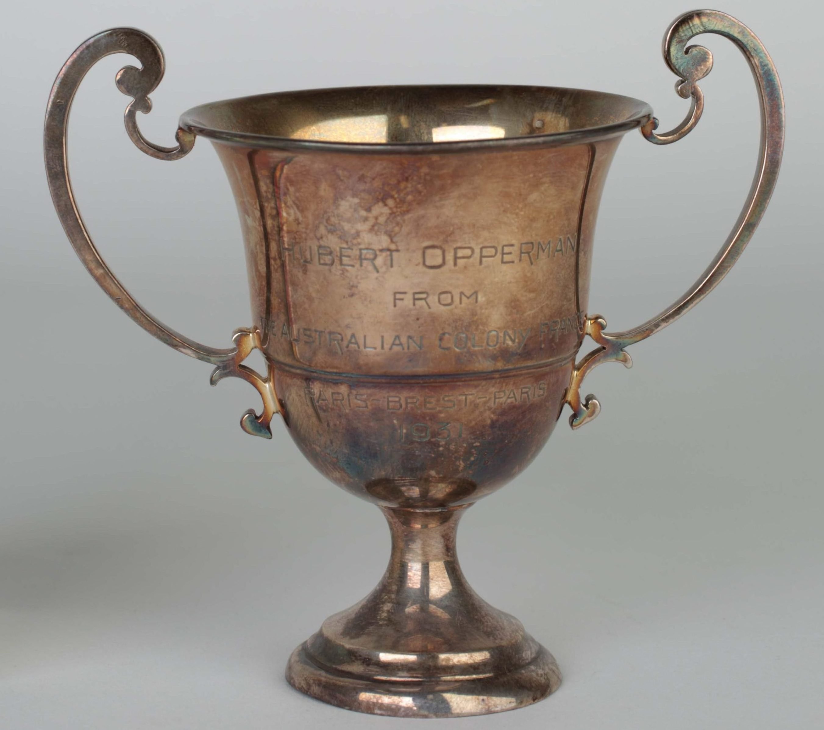 cup trophy engraved with Hubert Opperman showing tarnished surface
