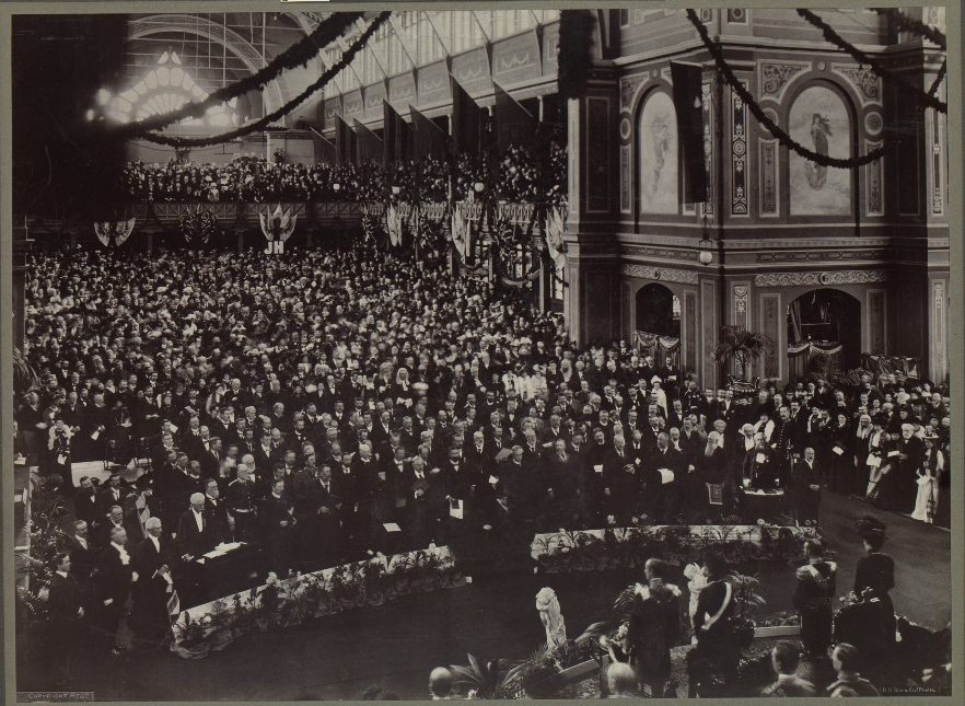 crowd of men in a building decorated with streamers