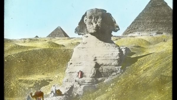 Pyramids and Sphinx and men with camels