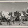 Group of men playing volleyball, tents in the Bonegilla Migrant Hostel