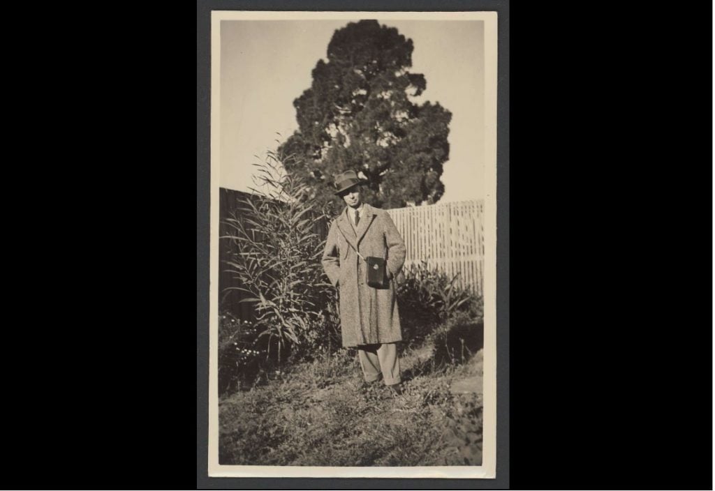 Black and white photographic portrait of a man standing in a garden