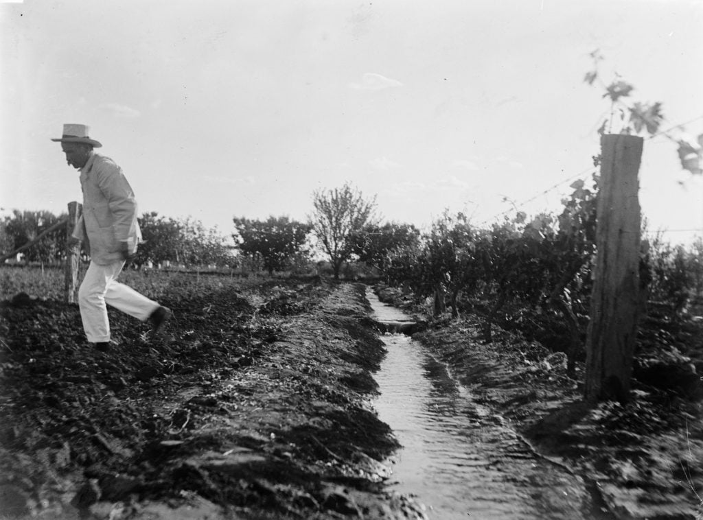 Picture right - Man having just jumped over an irrigation channel