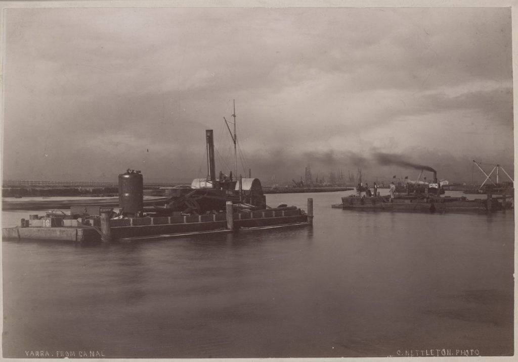 Picture right - view of the Yarra river, with boats, smoking funnels and sailing ships alongside a wharf in the background