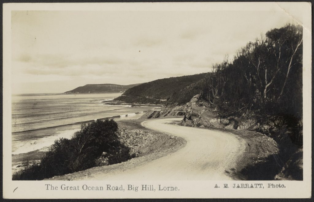photograph of newly laid road, with rolling in waves on the right hand side, coastline meandering along