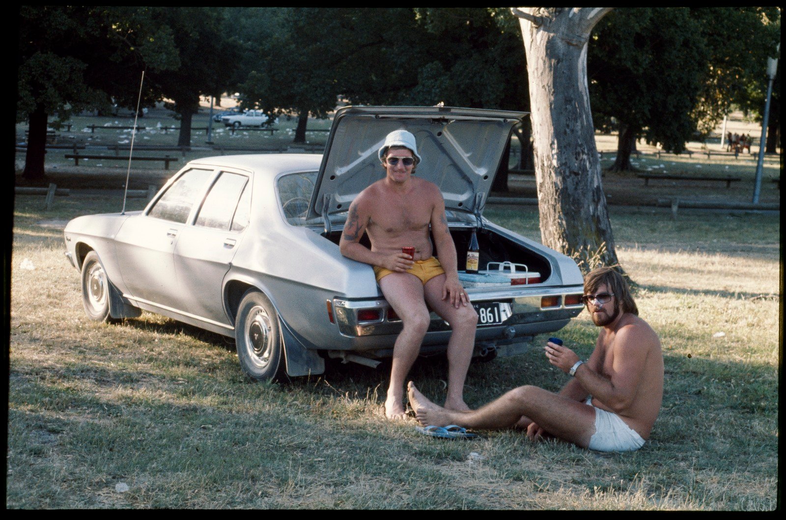 Two men drinking beer, sitting at the back of a Holden Kingswood