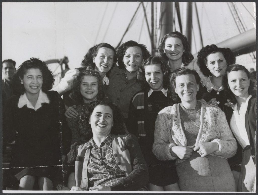 Black and white photo of a group of smiling women on the ship Arawa