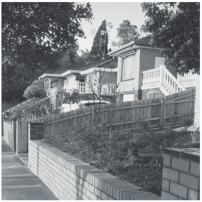 photograph, view along the street of double level houses with concrete balustrades and front gardens