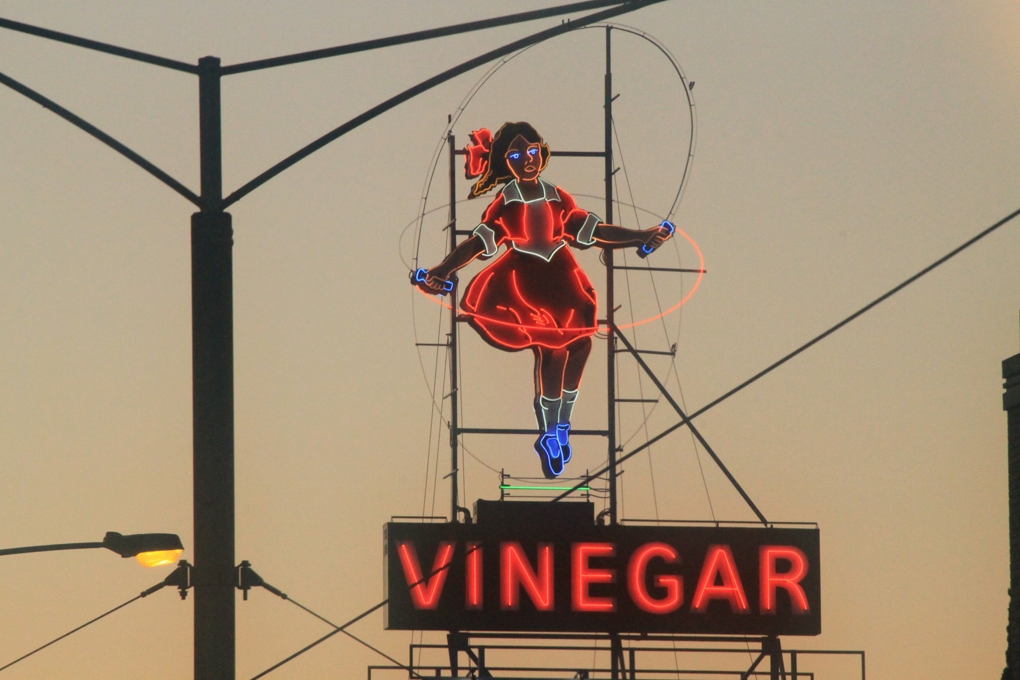Photo of neon Skipping Girl vinegar sign at dusk