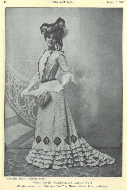 Black and white photo of woman in long sleeved dress with patterned bodice and fancy hat
