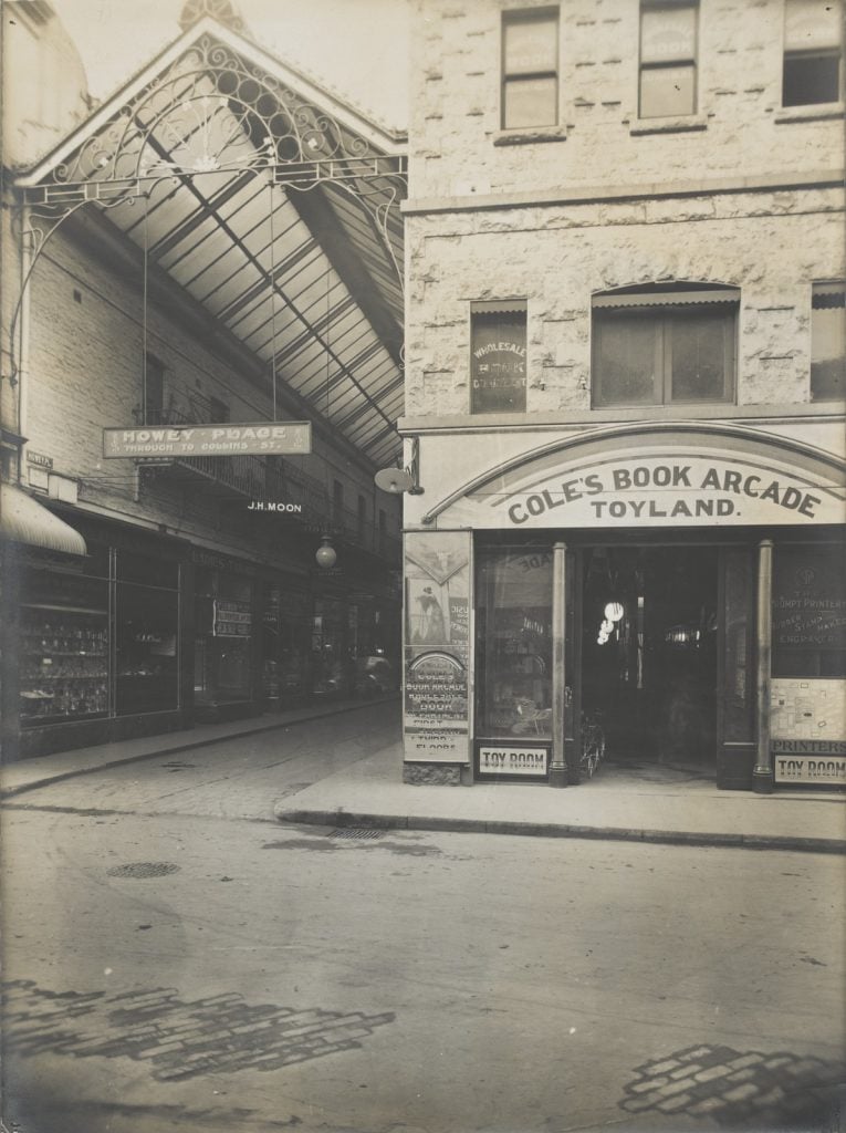 Black and white photograph showing entrance to Howey Place on left and entrance to ‘Cole’s Book Arcade: Toyland’ on the right.