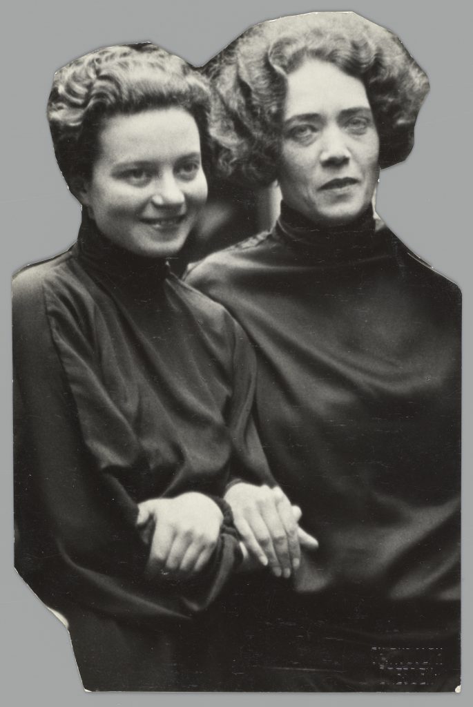 Black and white photograph, to waist, of Sonia Revid and Mary Wigman wearing black tunics with arms linked together.