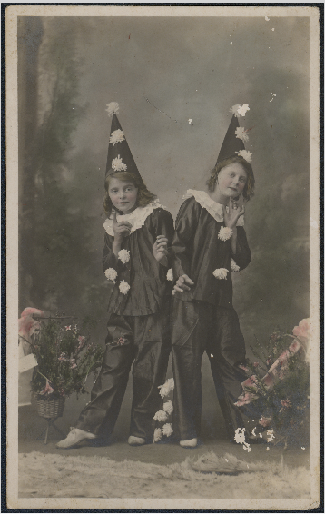 Studio portrait of two girls in clown costumes.