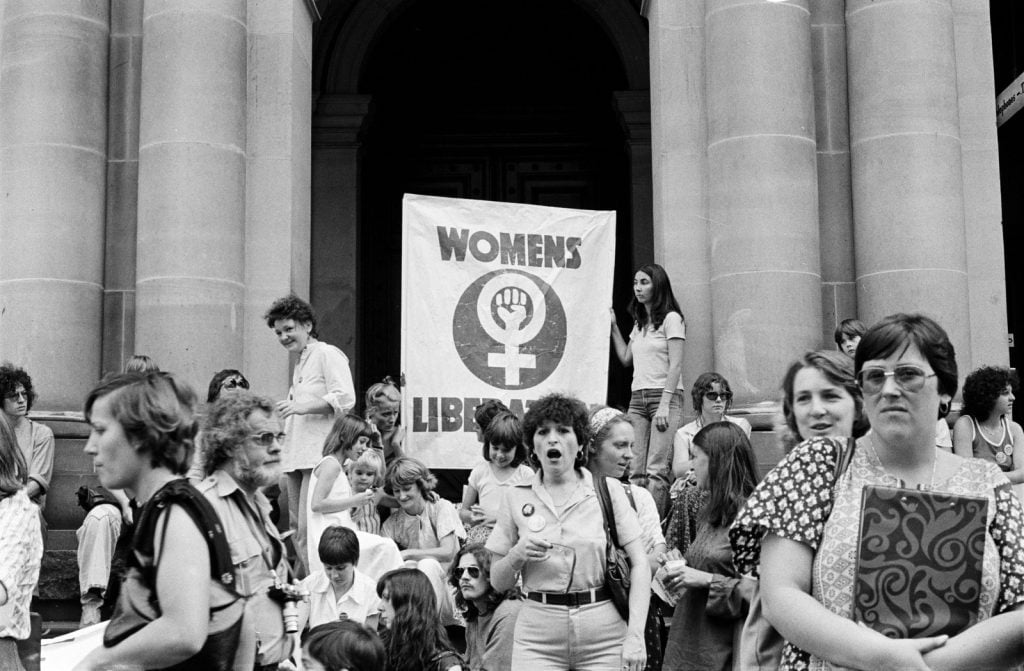 Black and white photograph of women protesting in favour of abortion. Two women hold a large sign reading 'Womens Liberation'.