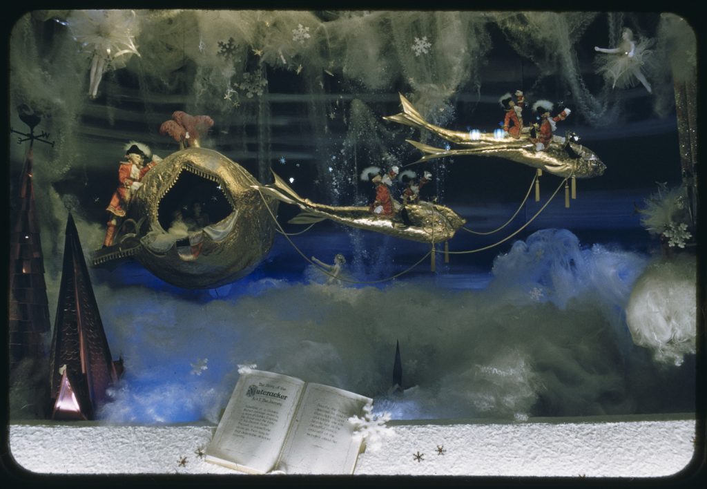 Colour image of Nutcracker themed  from a Myer Christmas window, showing what appears to be an 'underwater' scene with fish pulling a golden carriage with uniformed attendants. 