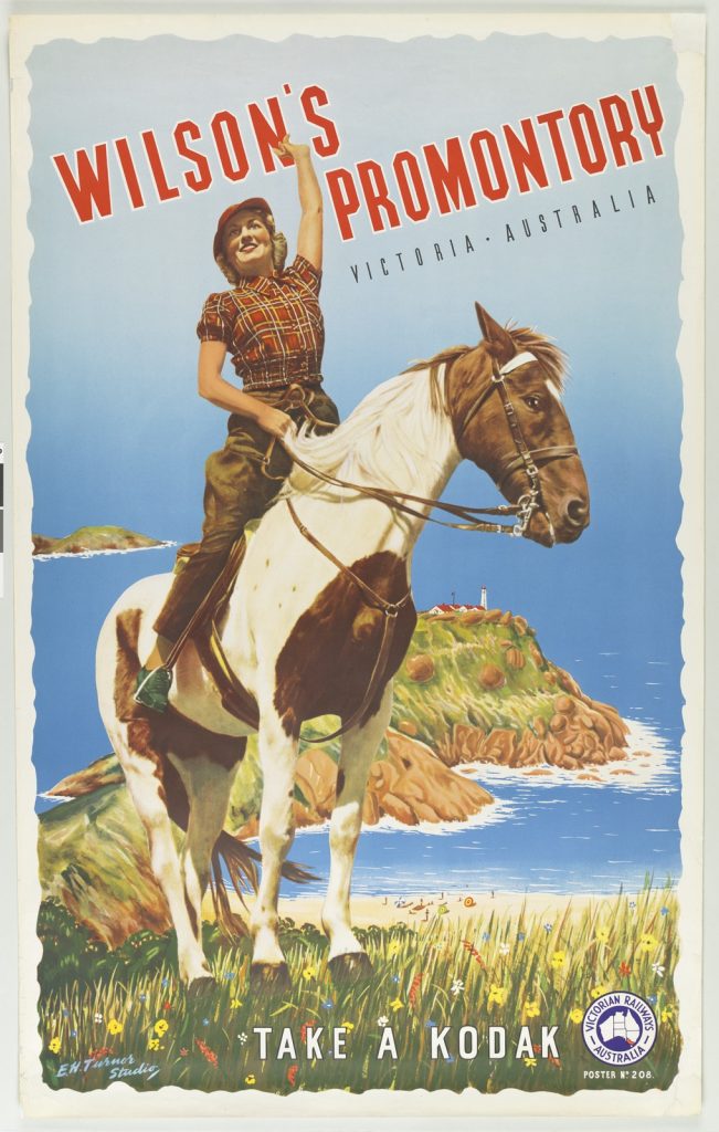 Poster promoting Wilson's Promontory, young woman on a piebald horse waving, with the Prom and lighthouse behind, text at the bottom, take a Kodak.
