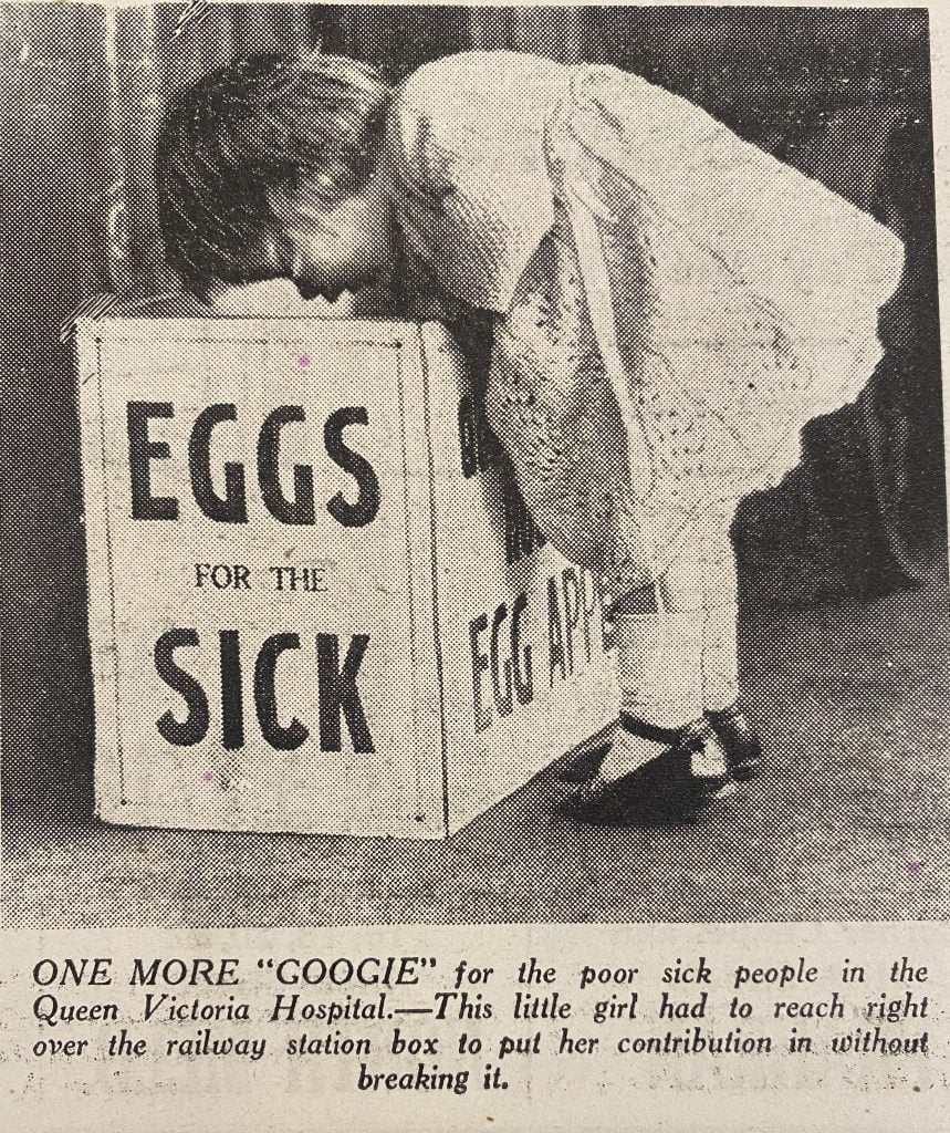 A child places an egg in the Eggs for the Sick box for the Queen Victoria Hospital.