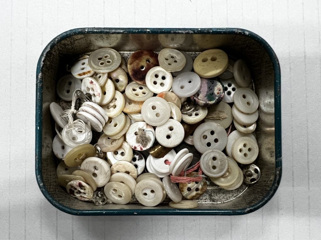 Vintage tin of buttons with the lid off