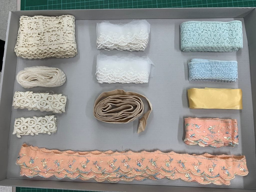 Pastel-coloured lace trims in a blue-grey board tray