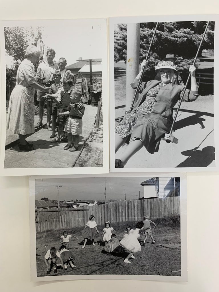 Three black and white photographs that appear to have been taken c. 1940s. One is of an old lady wearing an apron handing something out to children. The one on the right is of an old lady smiling while on a swing in a playground. The one on the bottom is of children playing in a yard.