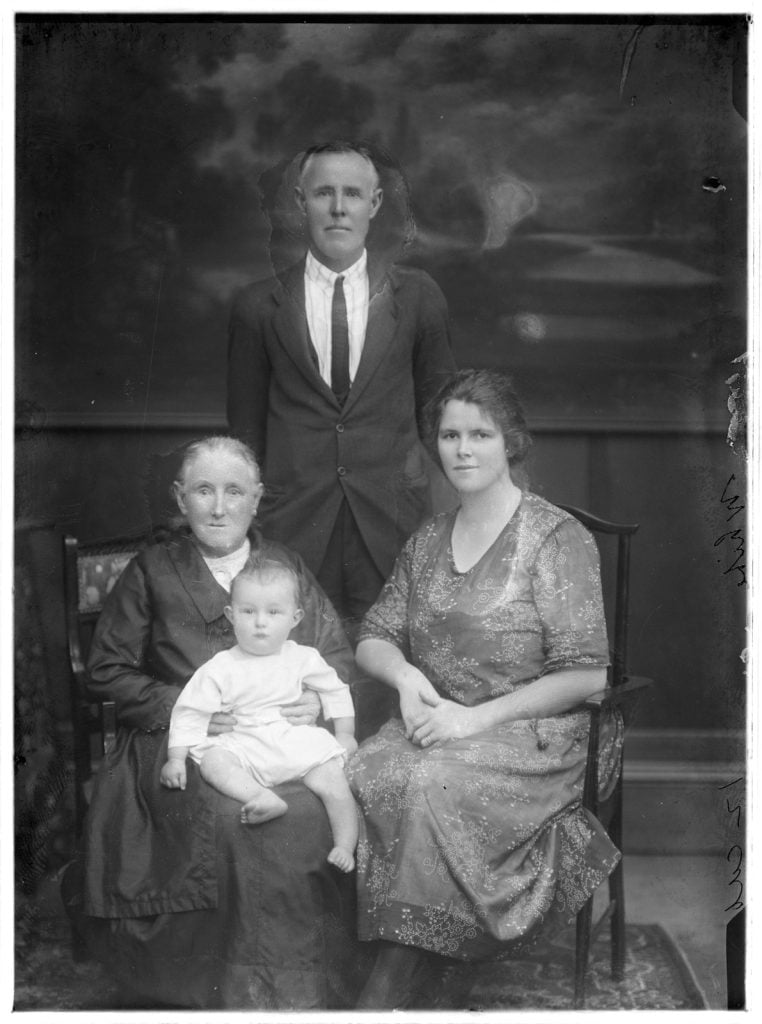 family photographic portrait with 3 or possibly 4 generations including a baby.