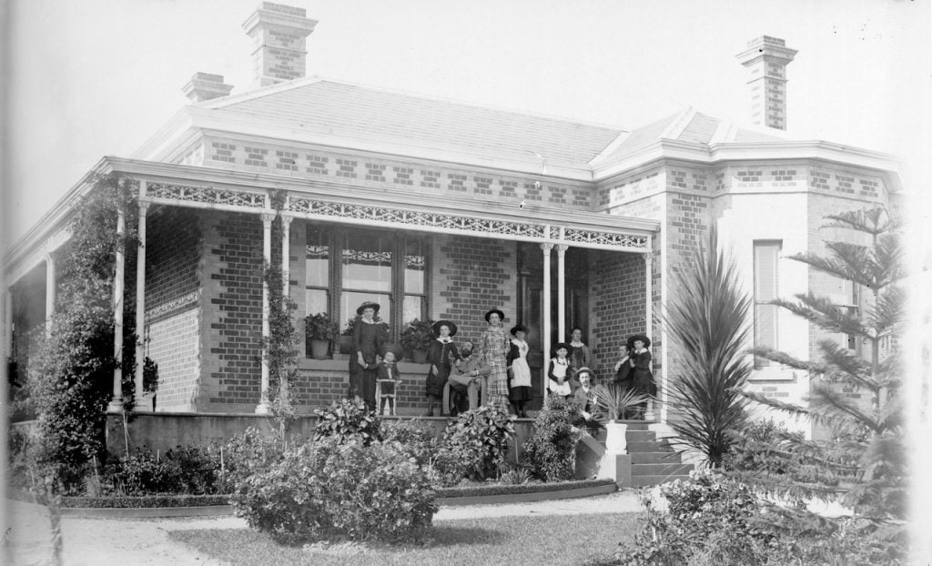 Photograph of family posed on verandah of house, probably in Melbourne