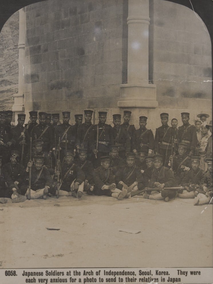 Close-up view Japanese soldiers standing and sitting at the Arch of Independence, Seoul, Korea, 1905. 