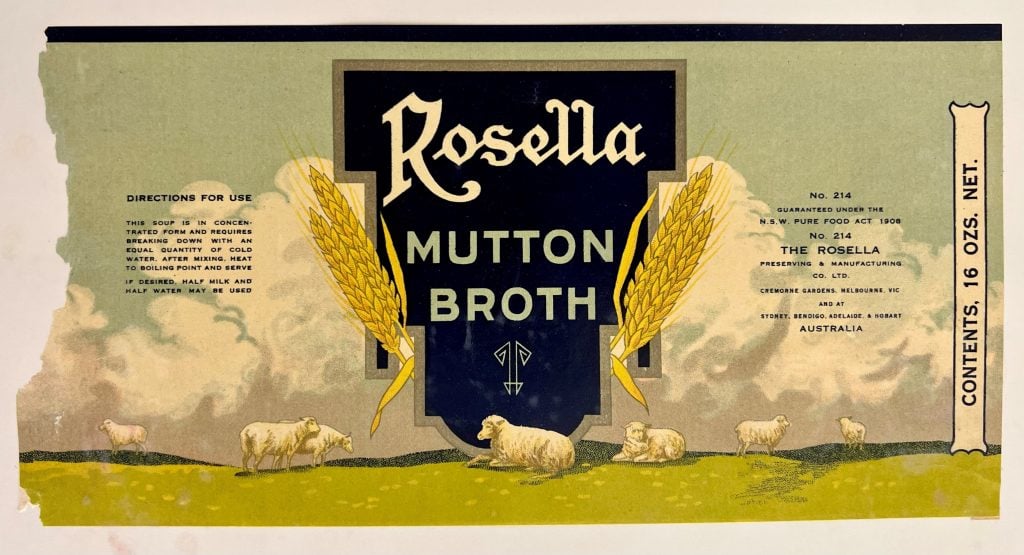 A torn, flattened label from a can of mutton broth, with a pastoral scene depicting sheep and wheat sheafs. 
