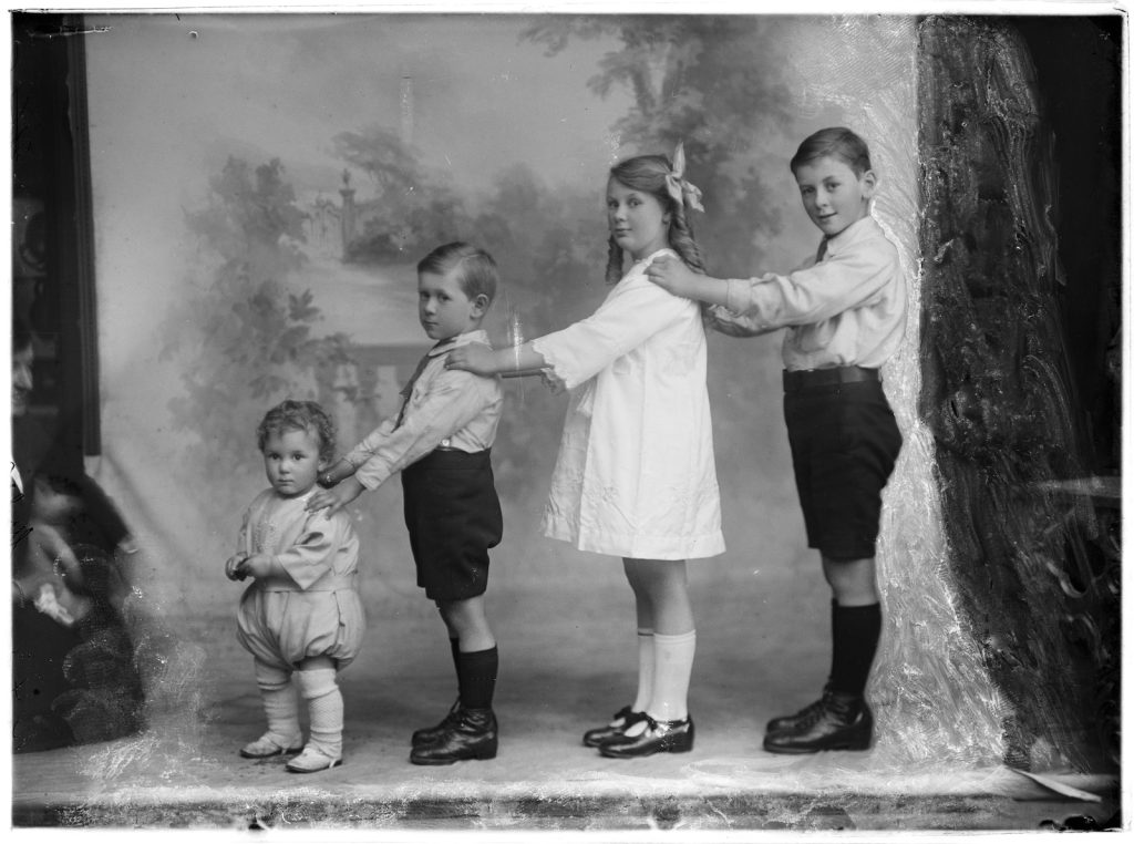 Studio portrait of four unidentified children standing in a row