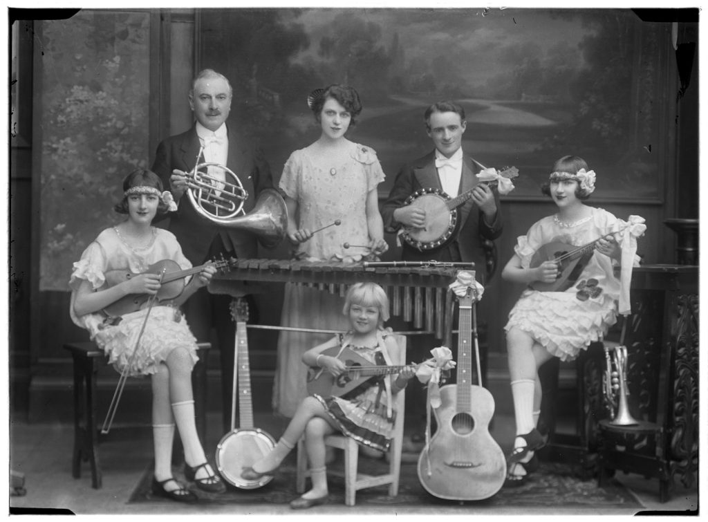 Studio portrait of a group of six people holding instruments, family name possibly Gard. 