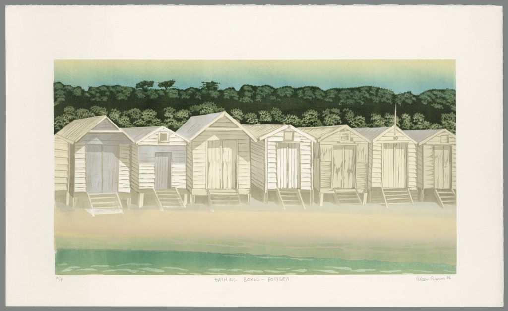 Beach view at Portsea with a row of bathing boxes on the sand and a line of trees and scrub behind.