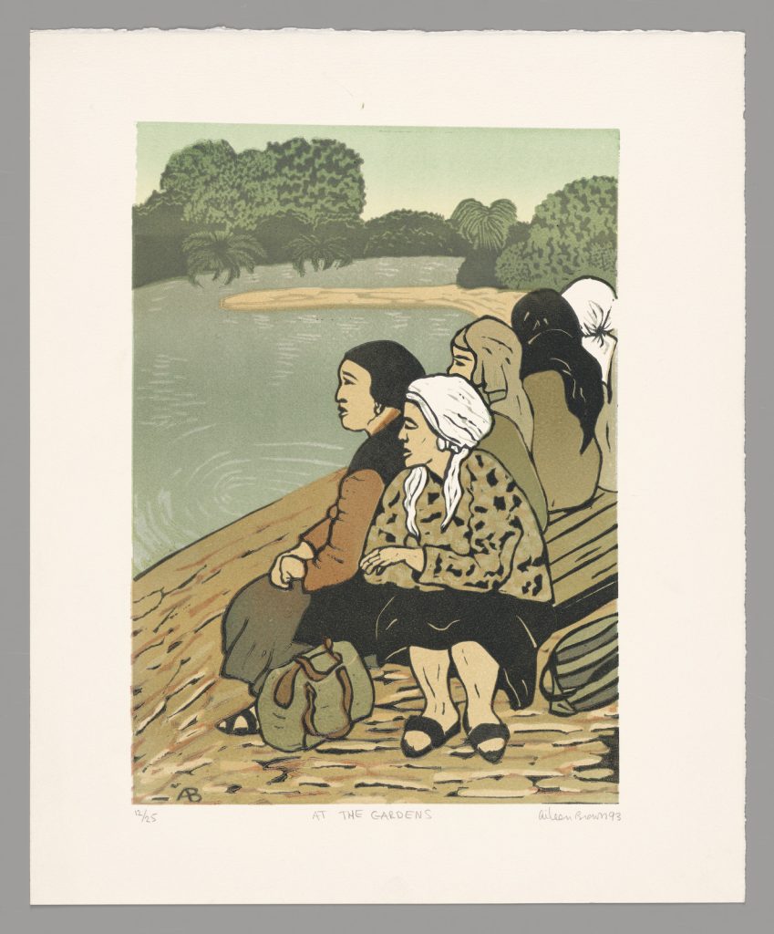 Five women wearing headscarves and head coverings seated beside a lake at the Royal Botanic Gardens Melbourne.