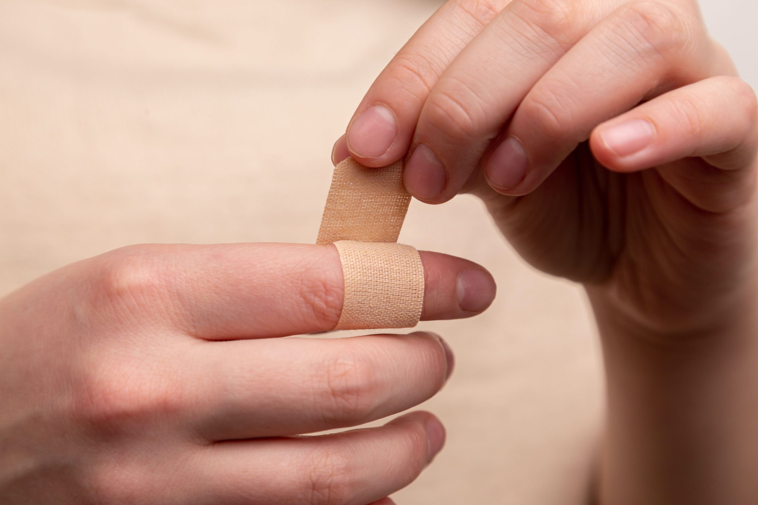 applying bandage to finger