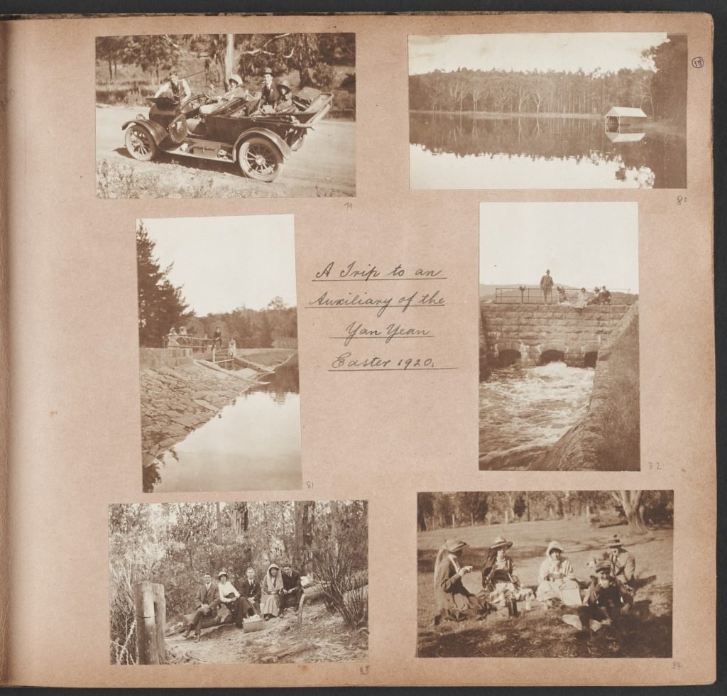 album page with 6 back and white photographs of a trip to Yan Yean reservoir: people in a car on a dusty road, looking up at the photographer; view across the still reservoir with reflections of trees in the water and a boat shed on the right hand side of the photo;  2 photos of 4 people standing on either edge of a weir at Yan Yean; the group siting on a log in amongst trees; the group having a picnic in a clearing.
