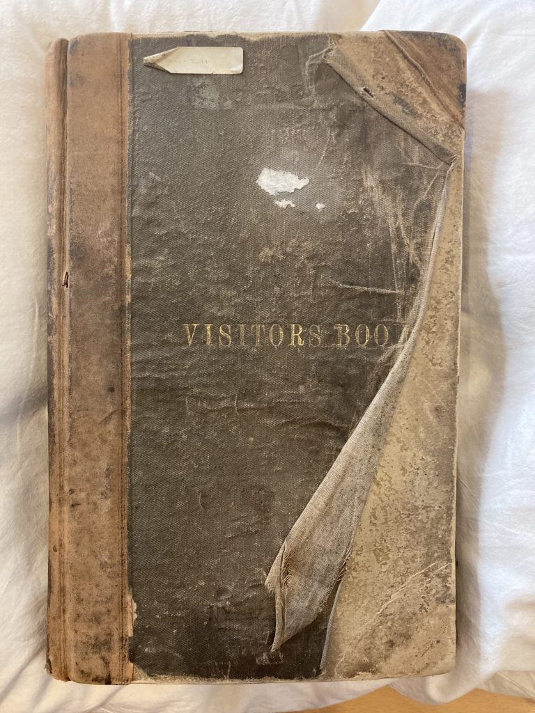 Hard cover volume with 'Visitors Book' printed on the front in gold letters