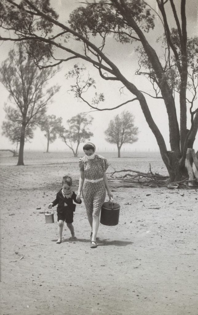 Sandstorm on farm near Wycheproof. Farmer's wife, Mrs Hazel Dunn and her small son walk through the sandstorm with handkerchieves on their faces. From  The Argus, 29 December 1944, page 6. 