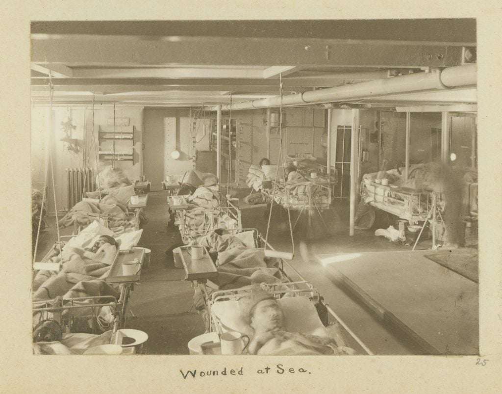 Wounded on board ship in hospital beds.