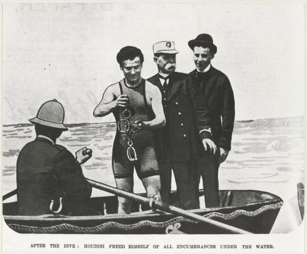 Houdini, chained behind his back, leaps into the Yarra River