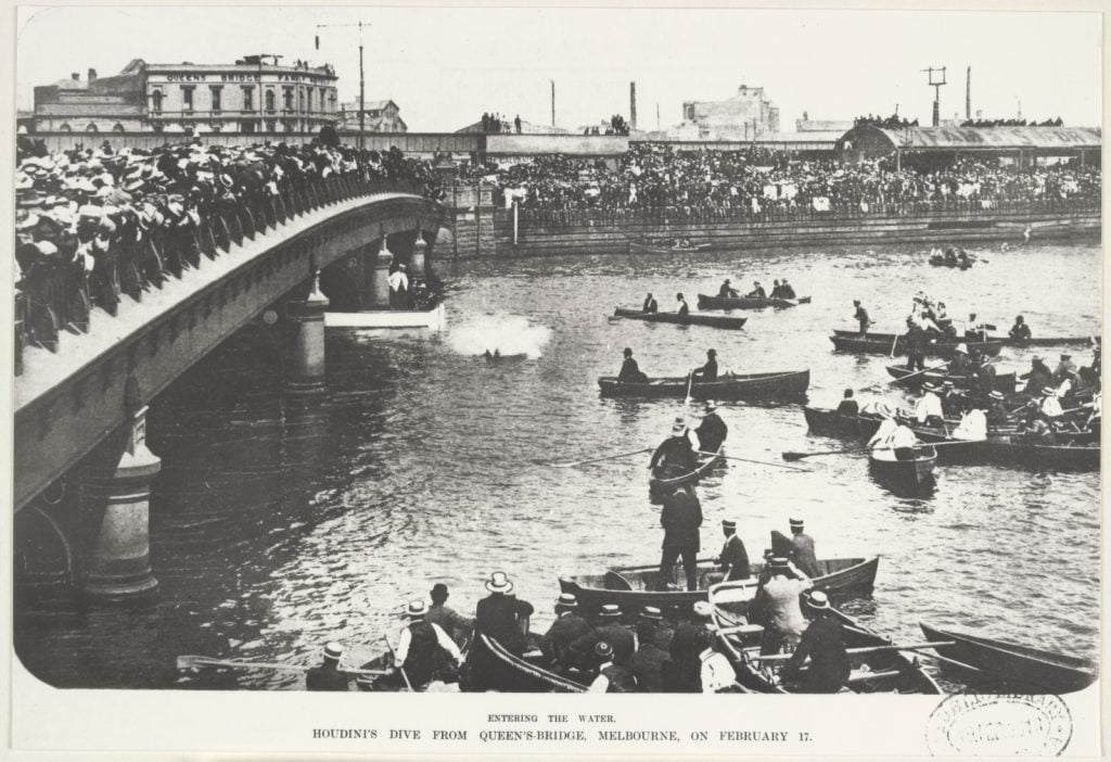 Houdini, chained behind his back, leaps into the Yarra River