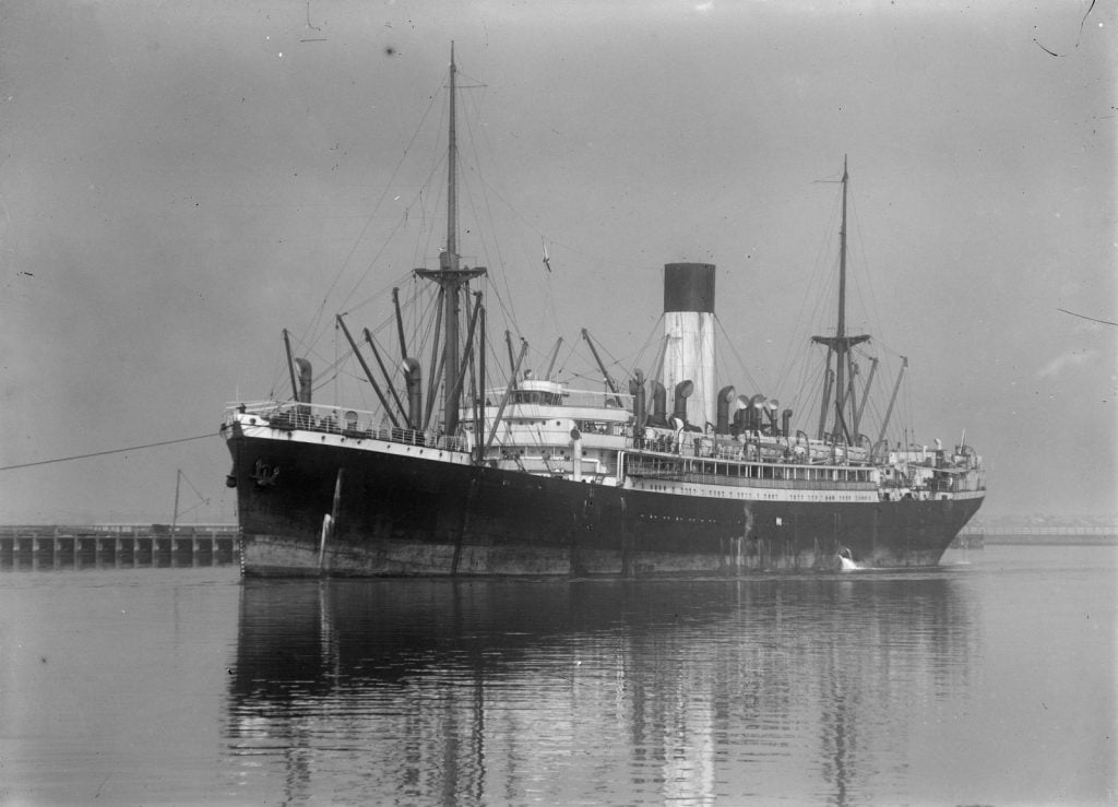 black and white photograph of of steam ship coming in to port