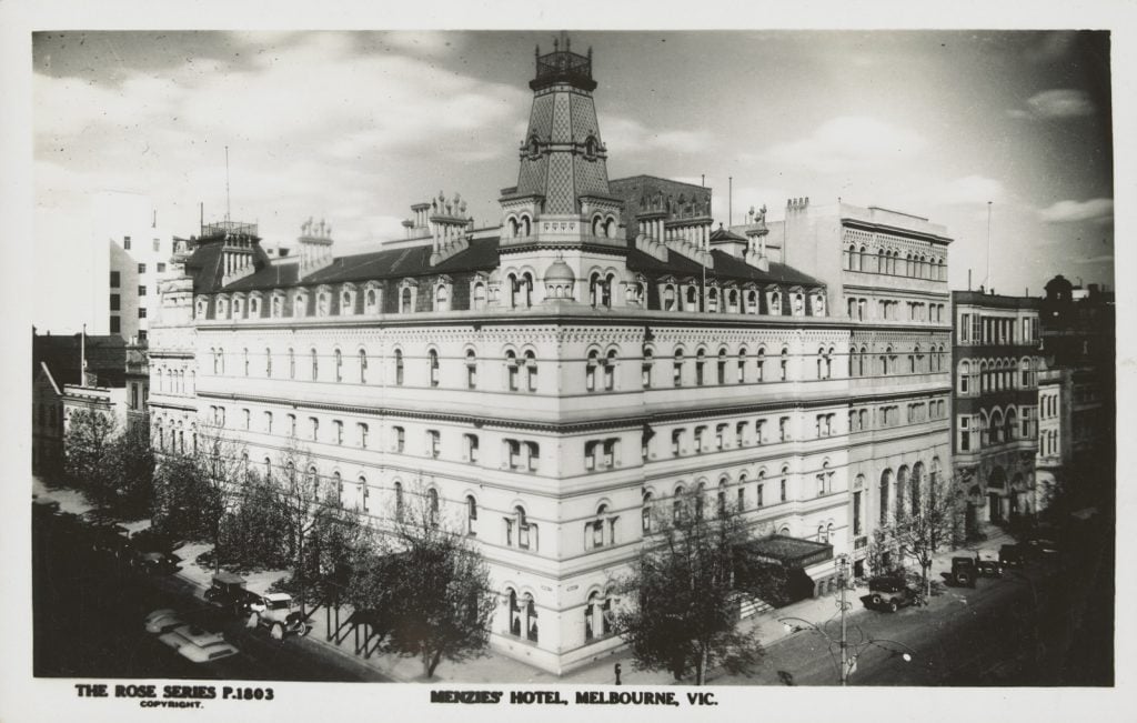 black and white picture of grand Menzies Hotel with white facade and turret at corner of block