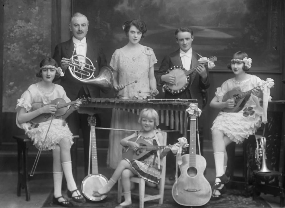 Family in formal dress each holding instruments