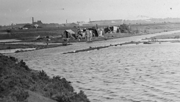 Black and white photo of a row of shacks made out of rubbish on the edge of the West Melbourne swamp