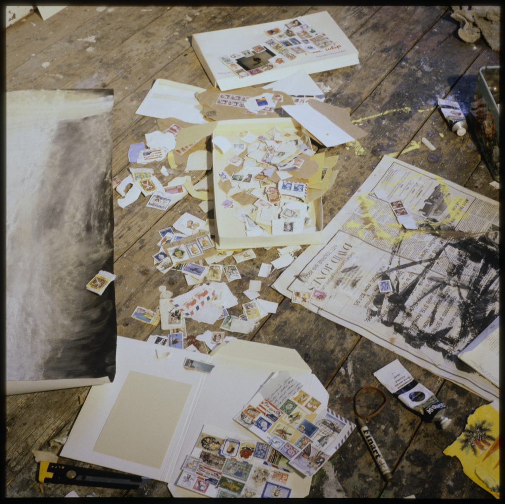 A photo of the material used by Brigid Courtney to create her artwork including postage stamps and torn paper.