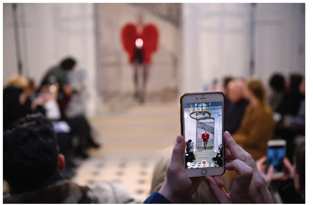 Runway and model seen through a mobile phone screen. The original image is blurred.