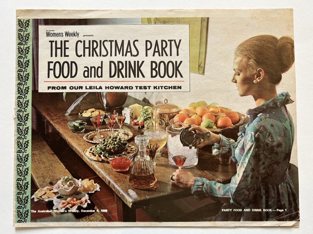 Colour photo of woman pouring a cocktail on a table of party food and drinks.