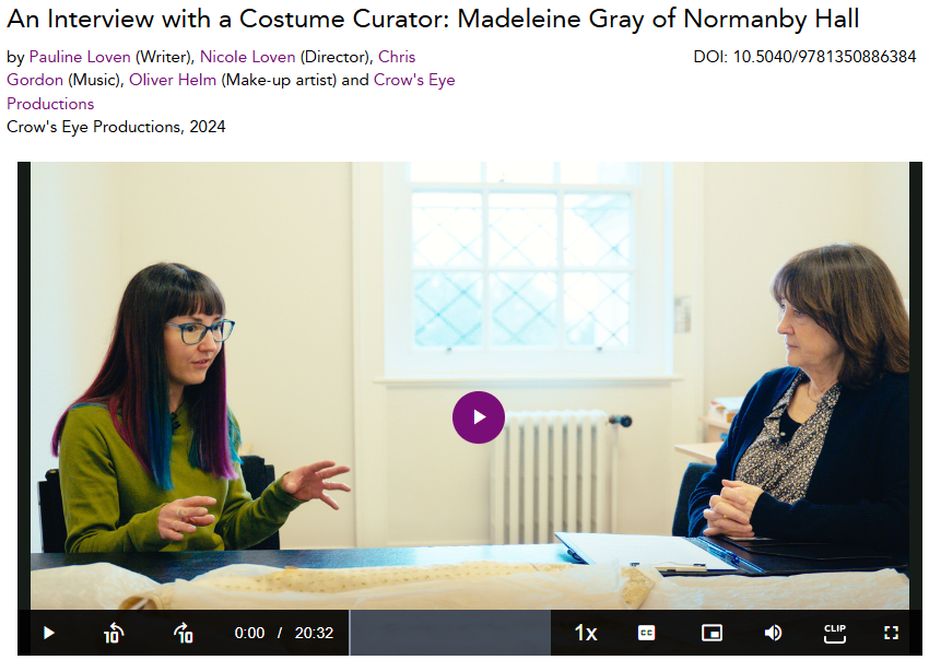 Zoomed in screen shot showing a still from the video An interview with a Costume Curator: Madeleine Gray of Normanby Hall. The image shows two women sitting at a table facing each other. The screen shot includes credit information about the creators. 