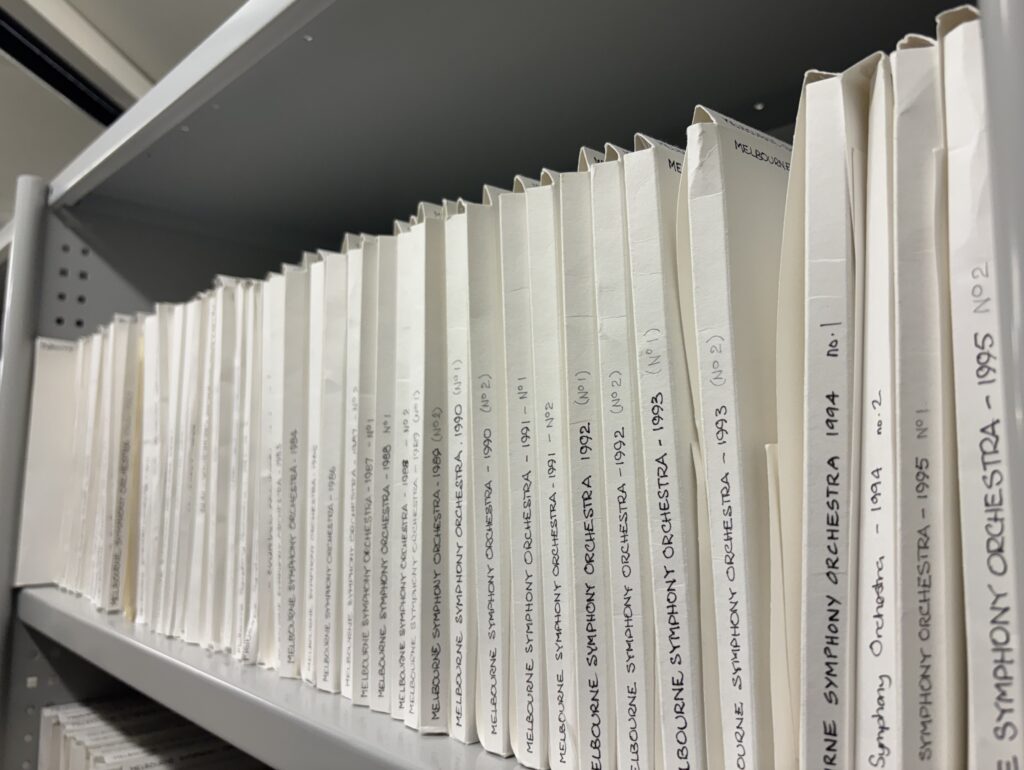 Row of theatre programme files on shelf with 'Melbourne Symphony Orchestra' written on spines